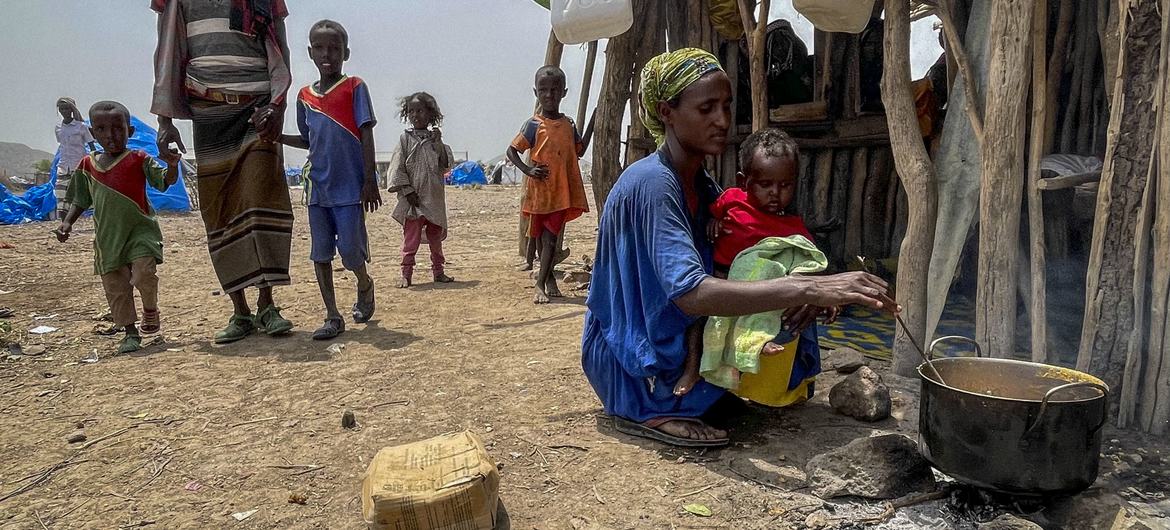 Une mère déplacée cuisine pour sa famille à Afar, en Éthiopie.